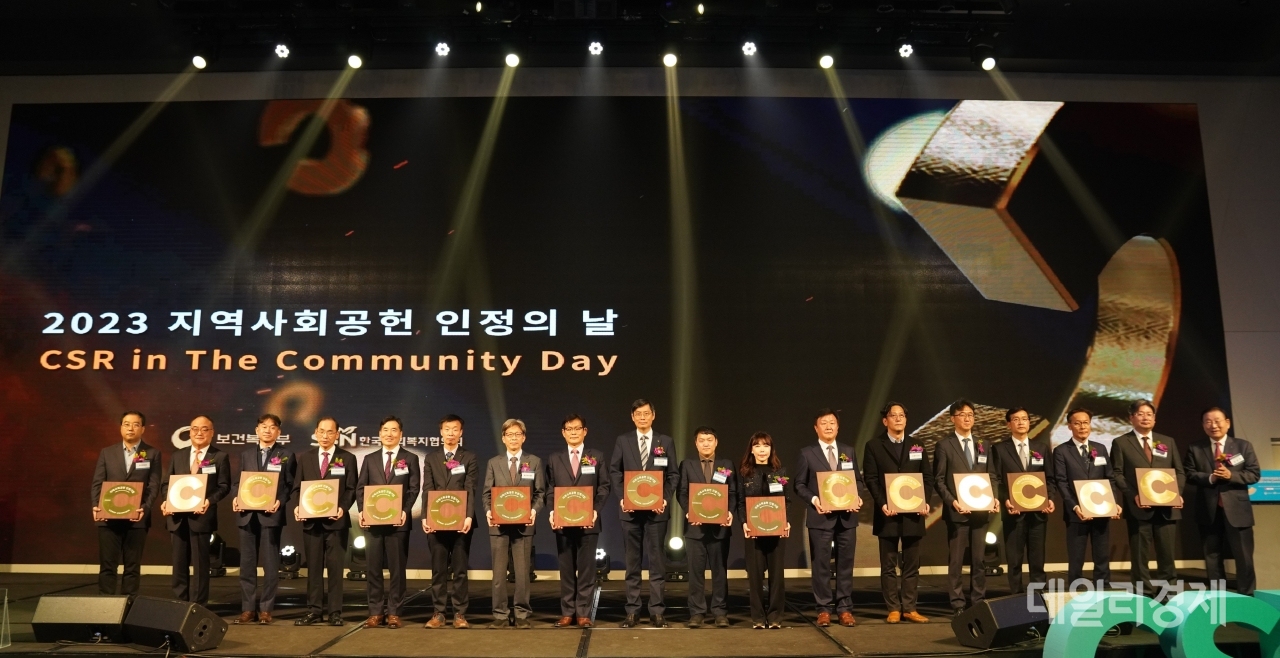 2023 지역사회공헌 인정의 날 기념식에서 김성이 한국사회복지협의회장(오른쪽 첫 번째)이 지역대표 인정기업·인정기관 17개소 대표들에게 인정패를 수여하고 함께 기념촬영을 하고 있다.